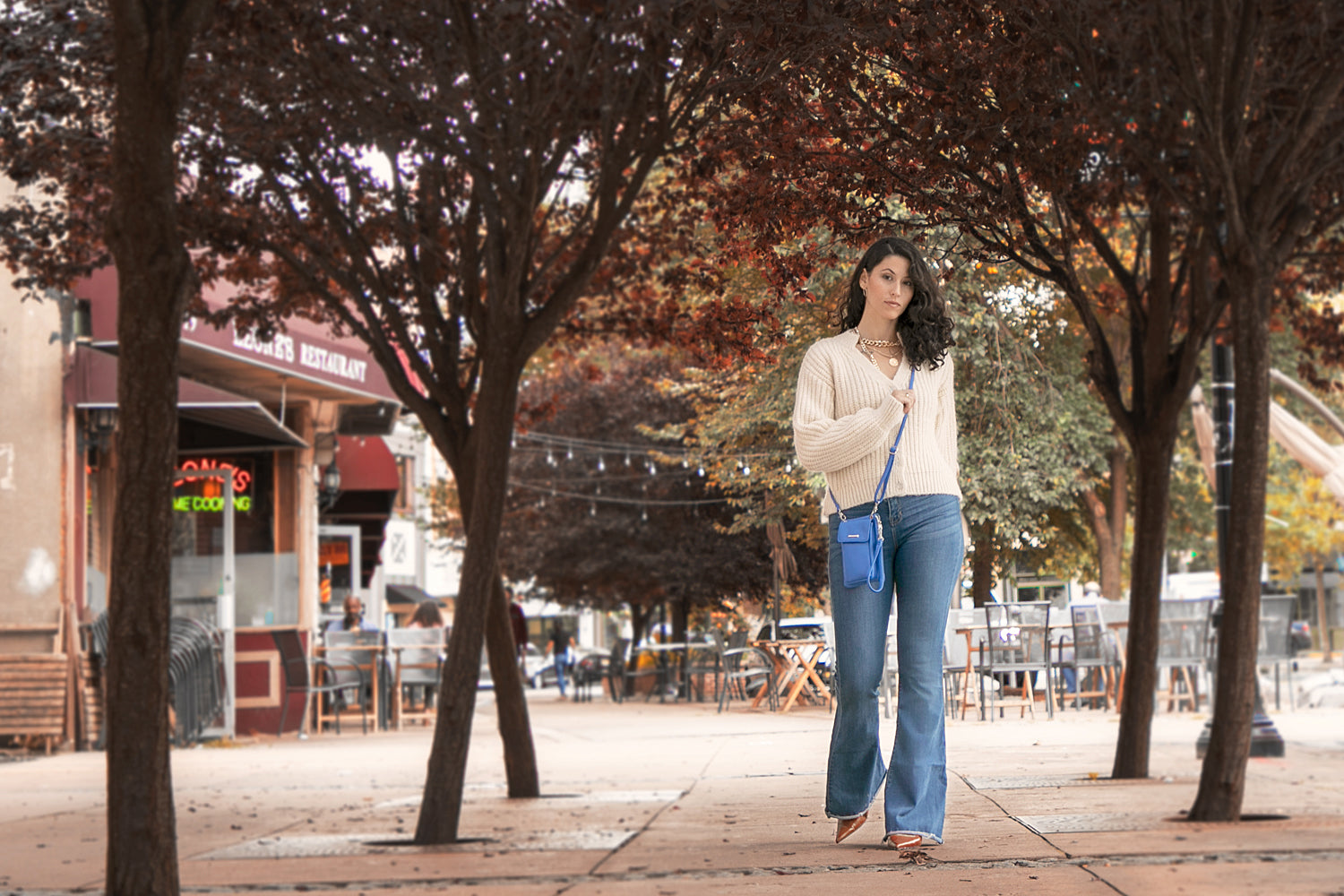 Best Bags and Wallets for Fall - Mundi Wallets - Pictured here is a woman walking down the street with her Azul Cornelia Cell Phone Bag.
